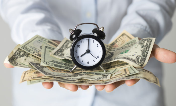 Woman holding a clock and cash