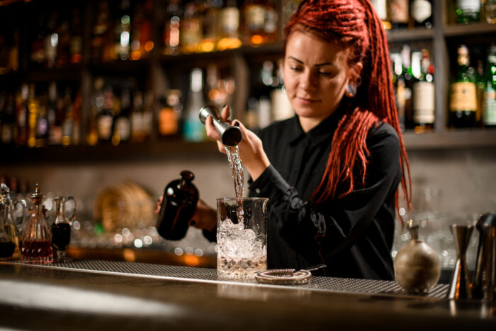 Female bartender pouring drinks